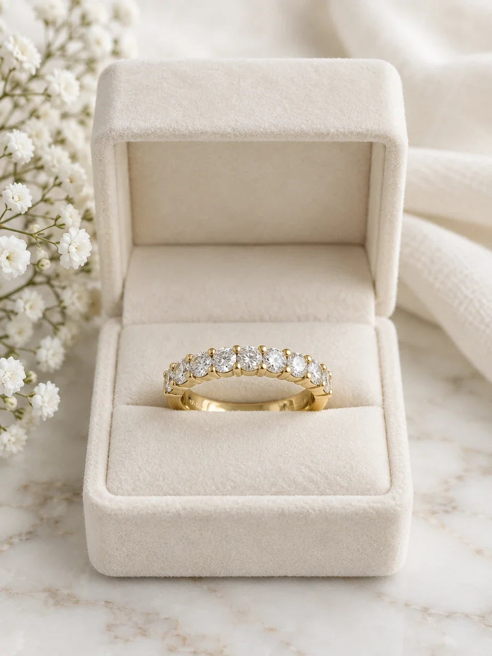 Yellow gold half eternity ring with a row of round diamonds in a cream velvet box
