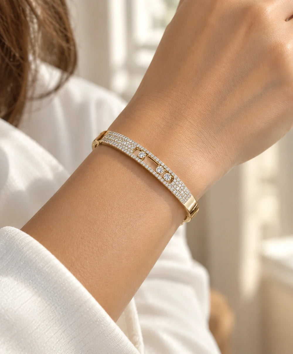 14K yellow gold diamond bangle bracelet worn on a woman's wrist