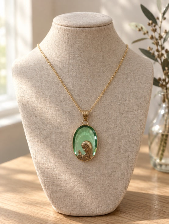 Green stone Virgin Mary pendant necklace in 14K gold on a jewelry bust