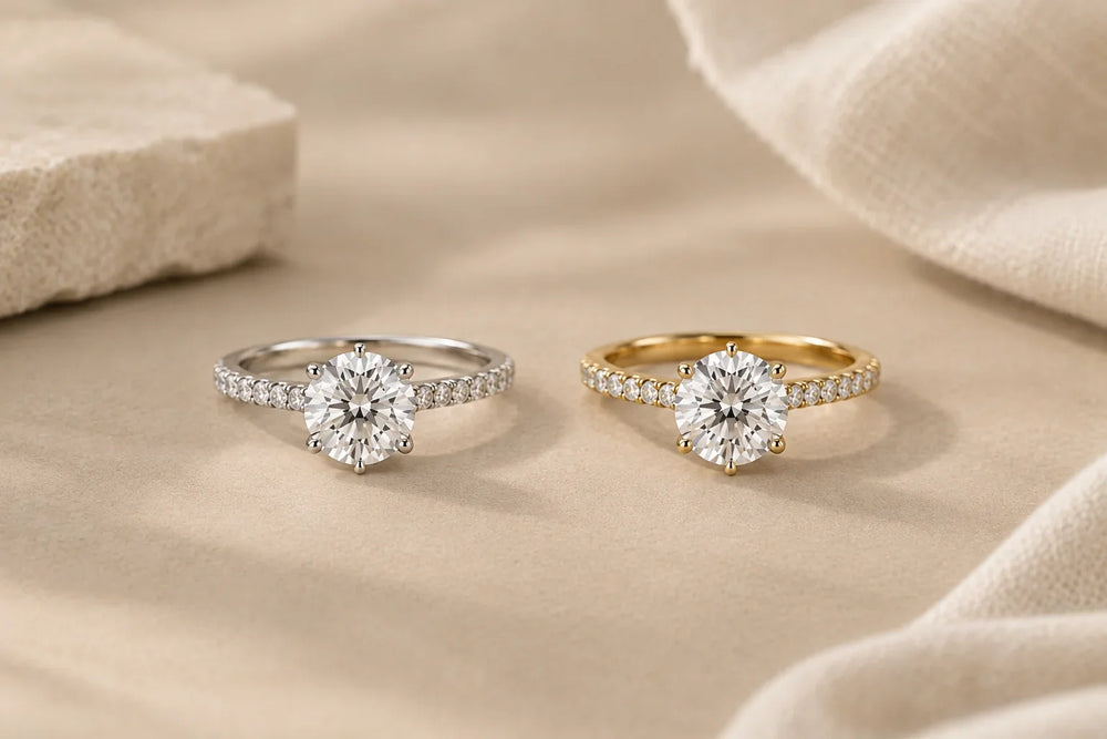 White gold vs yellow gold engagement rings side by side: two round solitaire diamond rings with pavé bands