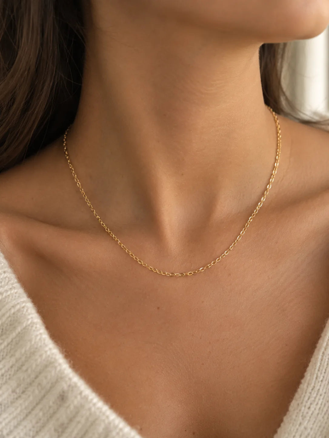 18K yellow gold chain necklace worn on a woman's collarbone
