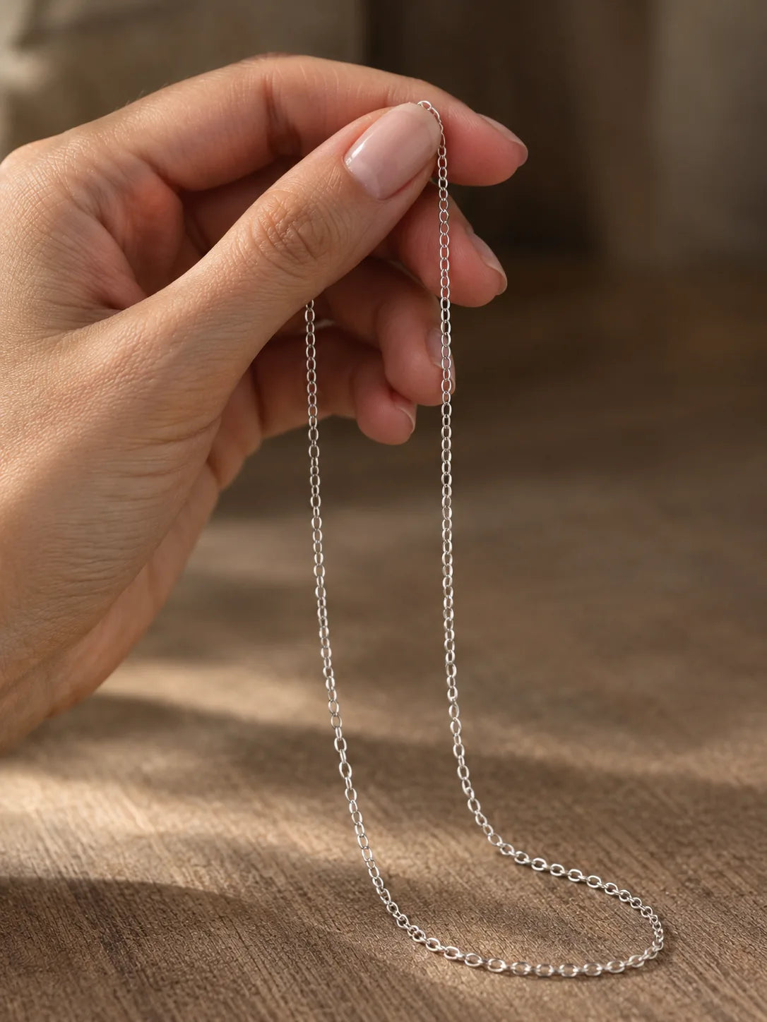 Fine 18K white gold chain for women held in a hand