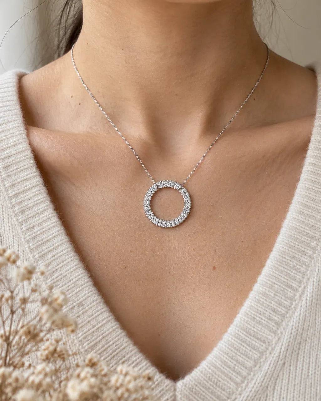 Woman wearing a diamond circle necklace in 14K white gold below the collarbone