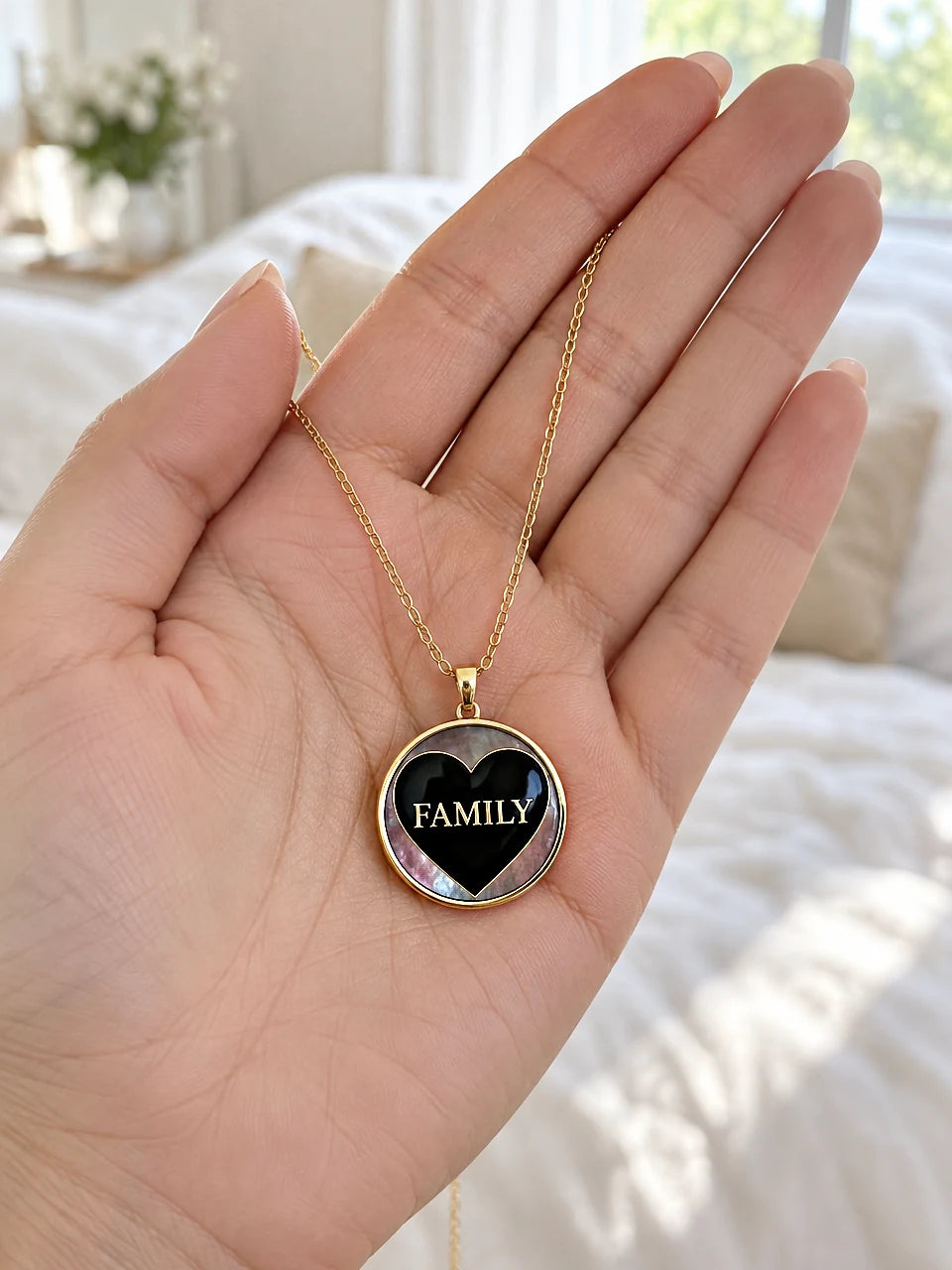 FAMILY heart pendant necklace in 14K gold held in an open hand