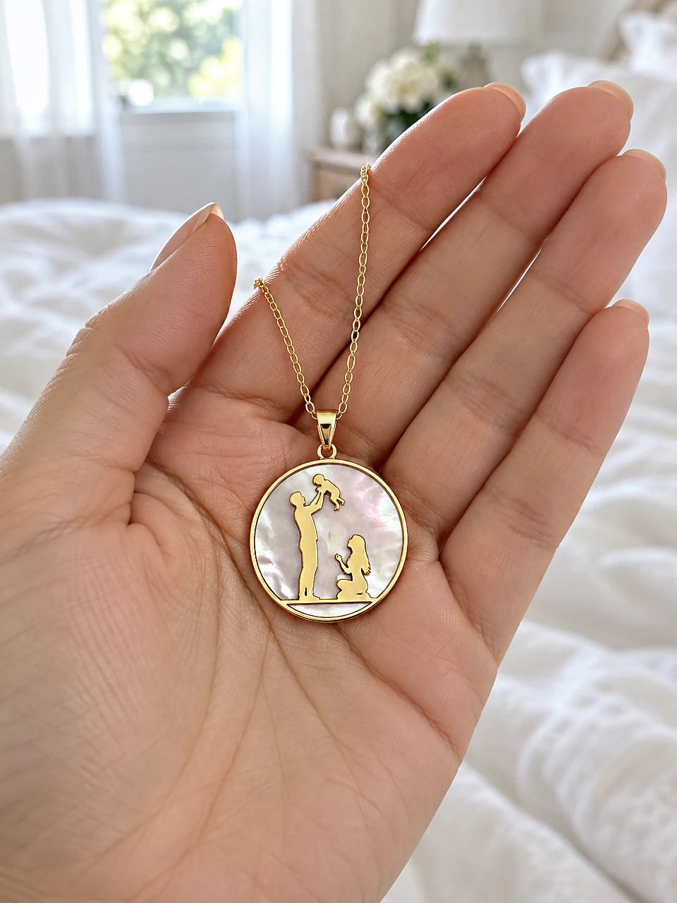 Father and child family pendant necklace in 14K gold held in an open hand