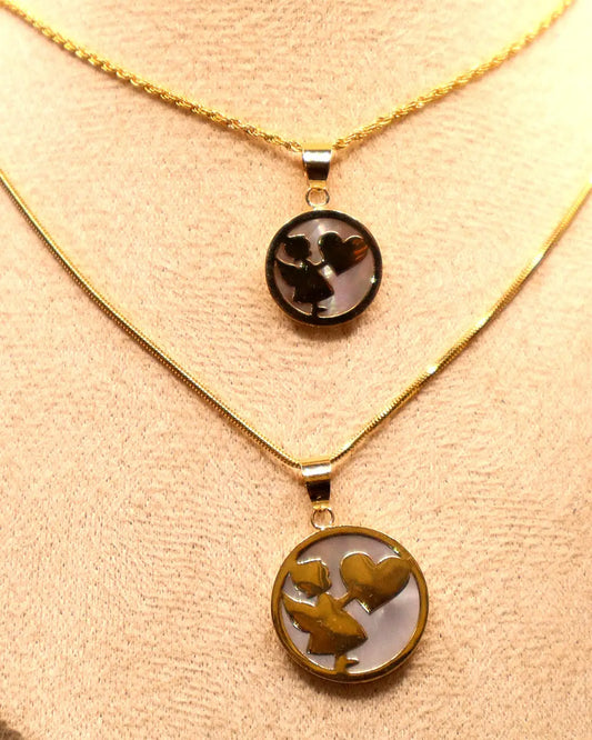 Girl with heart pendant necklaces in 14K gold and mother-of-pearl, small and large size, on a beige bust