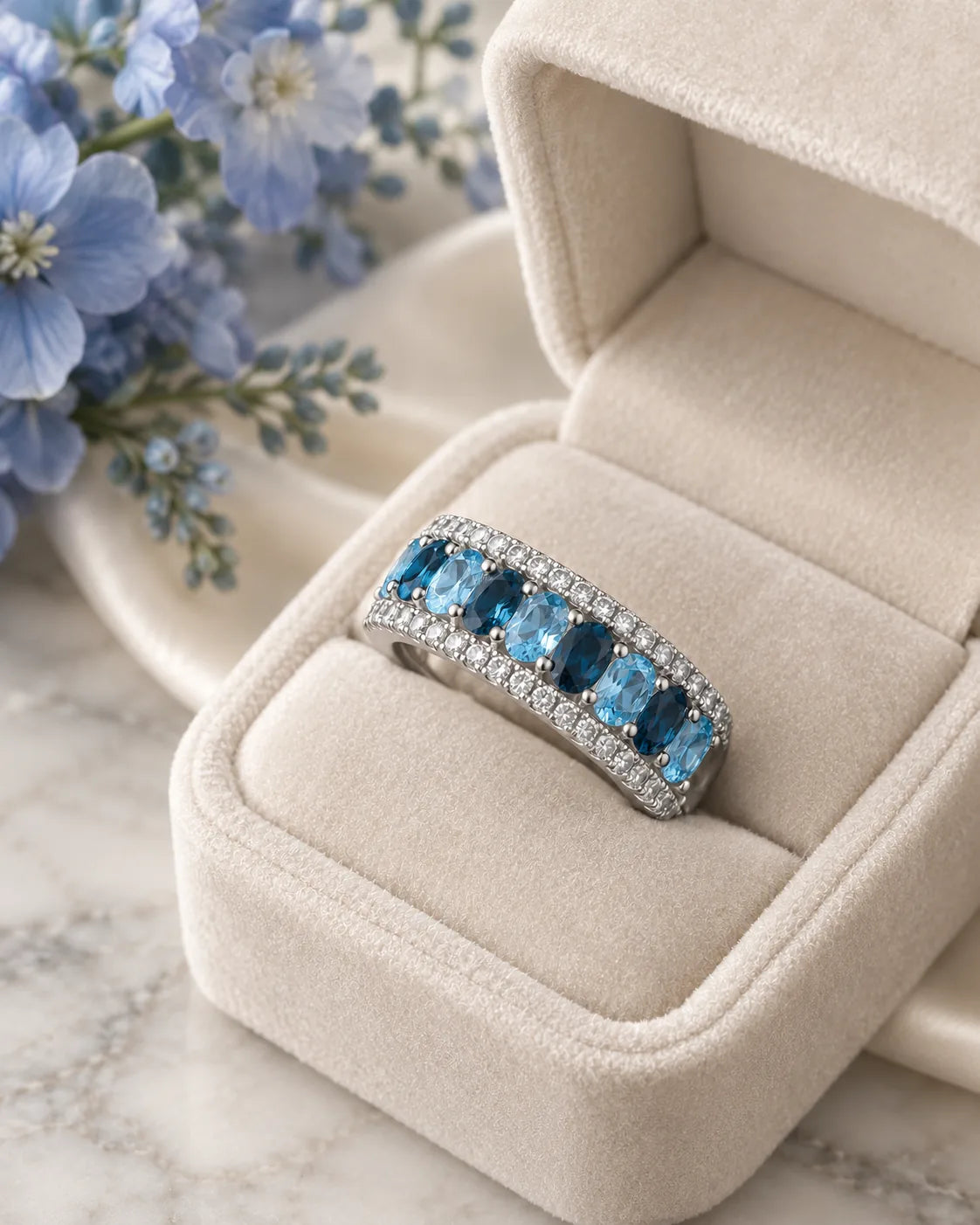 London blue topaz cocktail ring set in 14K white gold, both rings stacked together in a velvet ring box