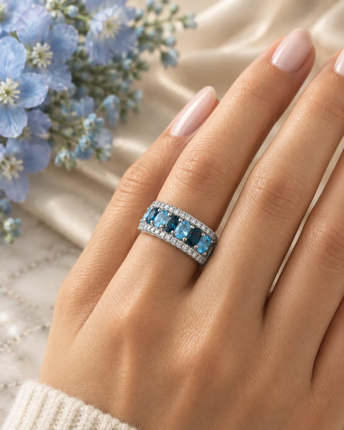 London blue and Swiss blue topaz rings stacked as one wide cocktail ring, worn on a woman's hand