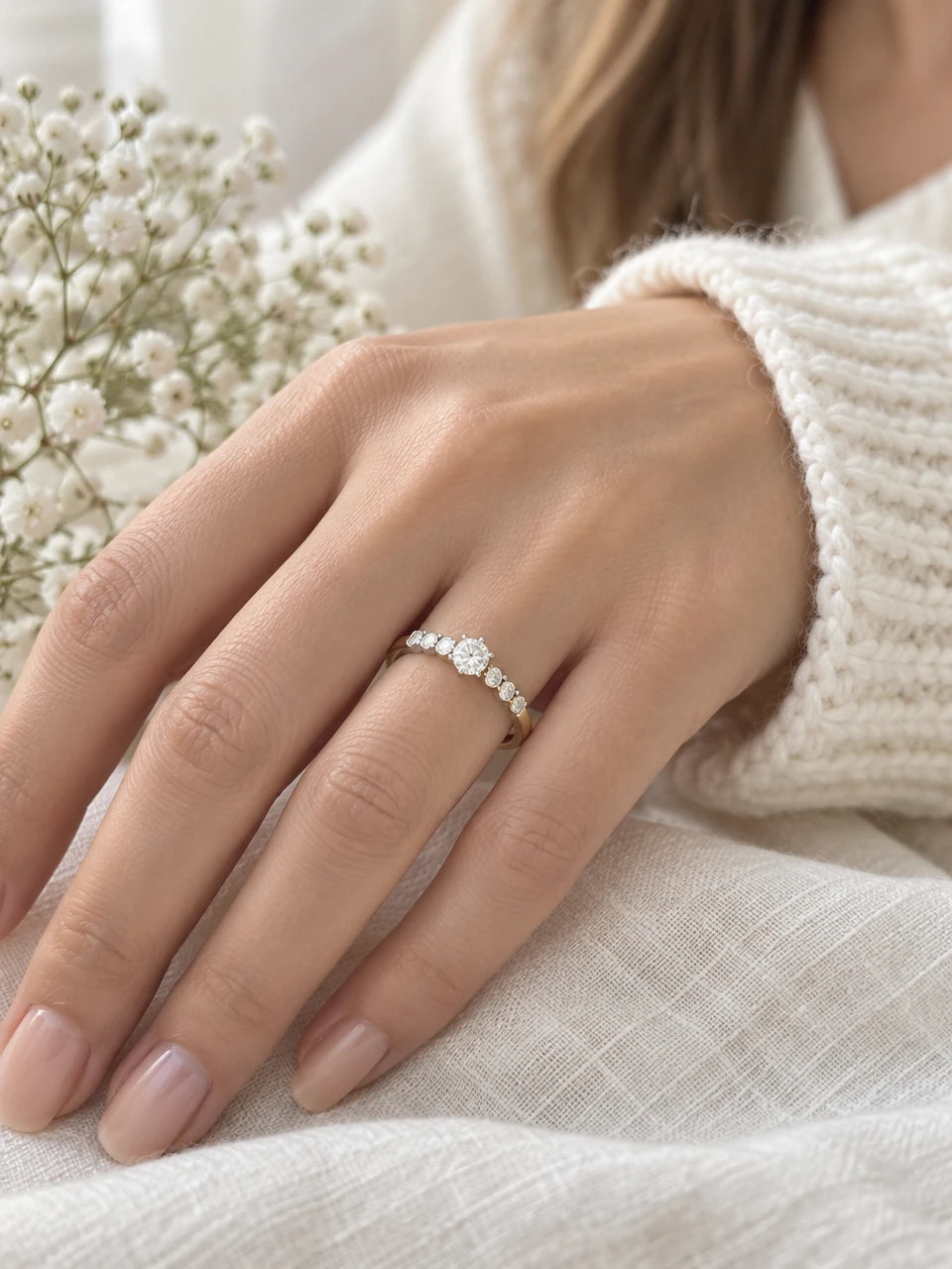 Two-tone yellow and white gold engagement ring worn on a hand