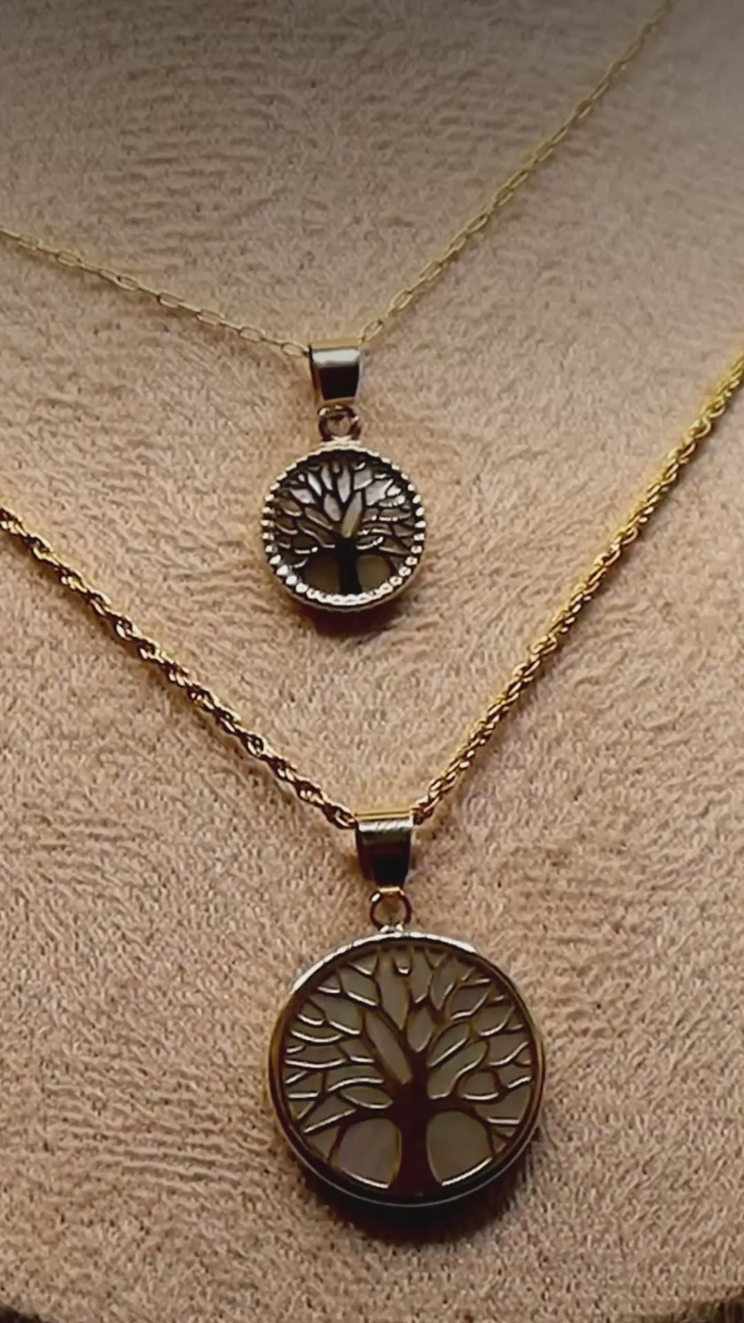 Close-up video of the 14K yellow gold Tree of Life pendant necklaces on a display bust