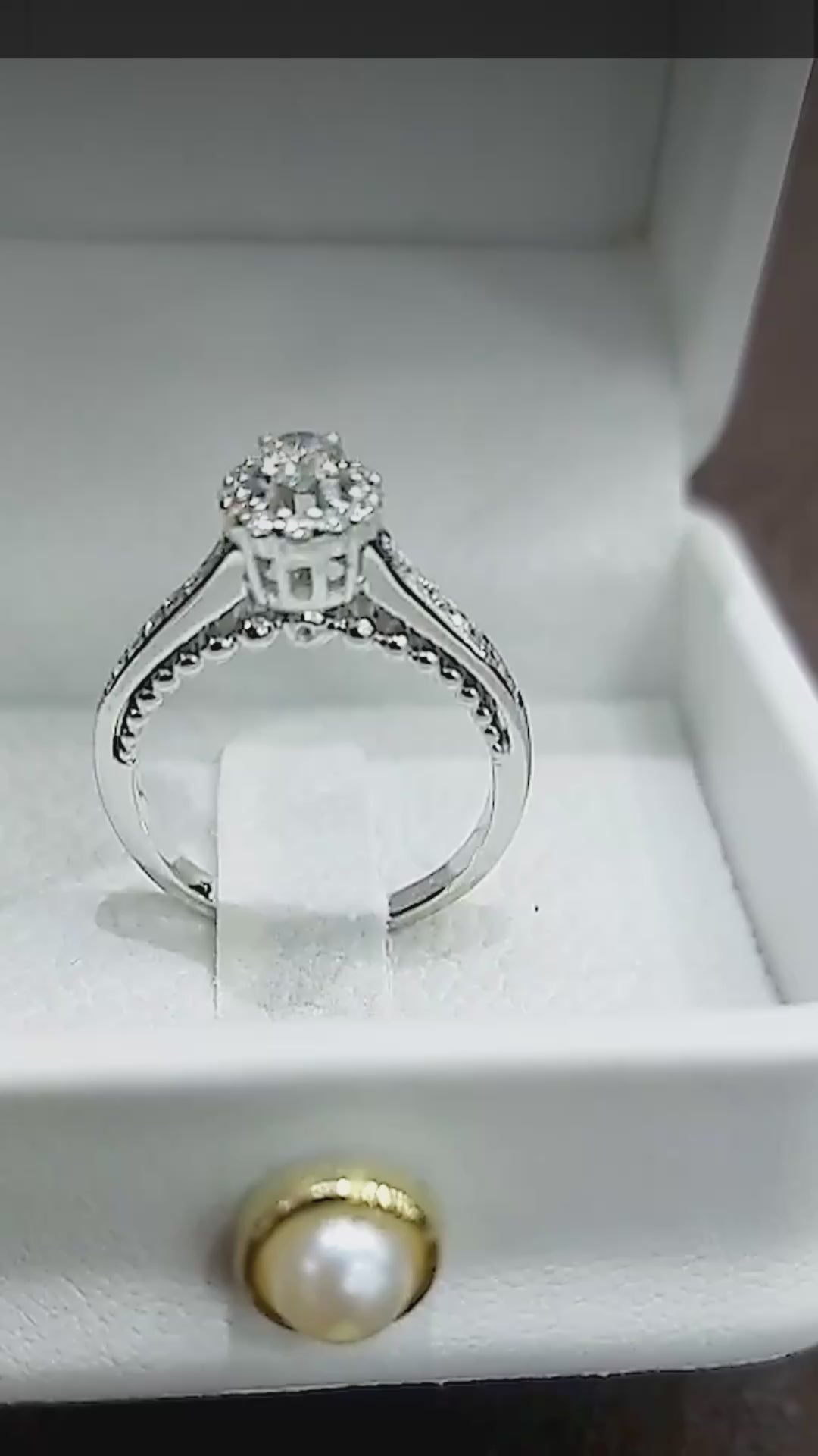 Close-up video of the 14K white gold hidden halo engagement ring, with diamonds tucked under the centre stone