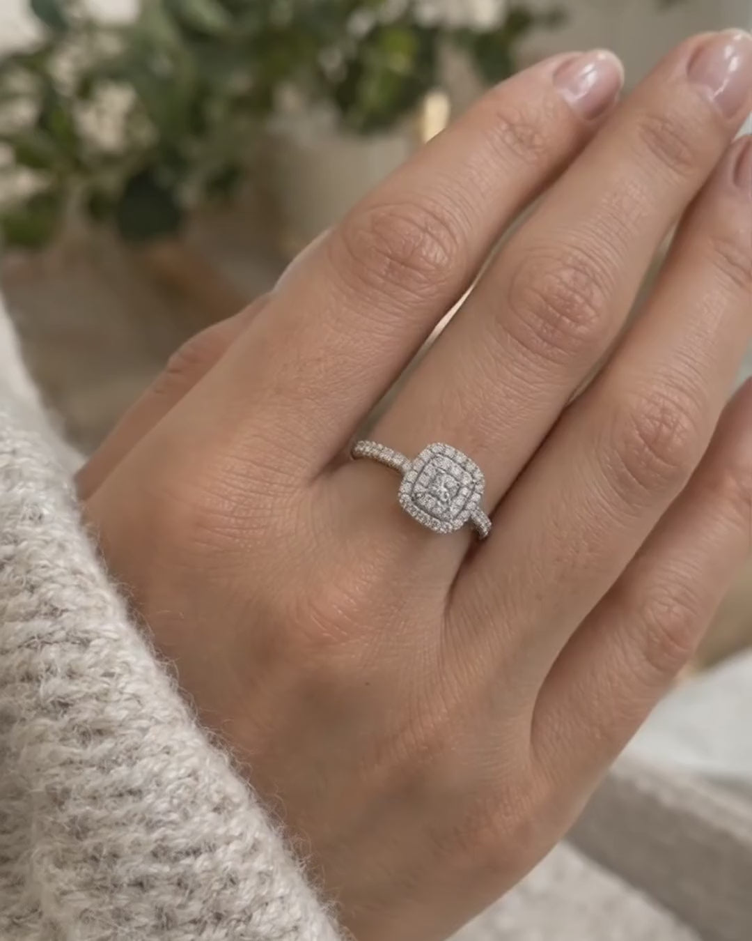 Video of the double halo cushion cut engagement ring in 14K gold worn on a woman's hand, showing both rows of pavé diamonds