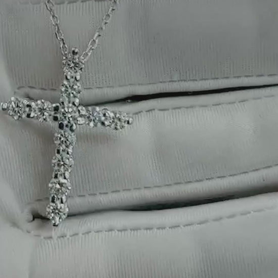 Close-up video of the 18K white gold diamond cross necklace on a glove and on a display bust