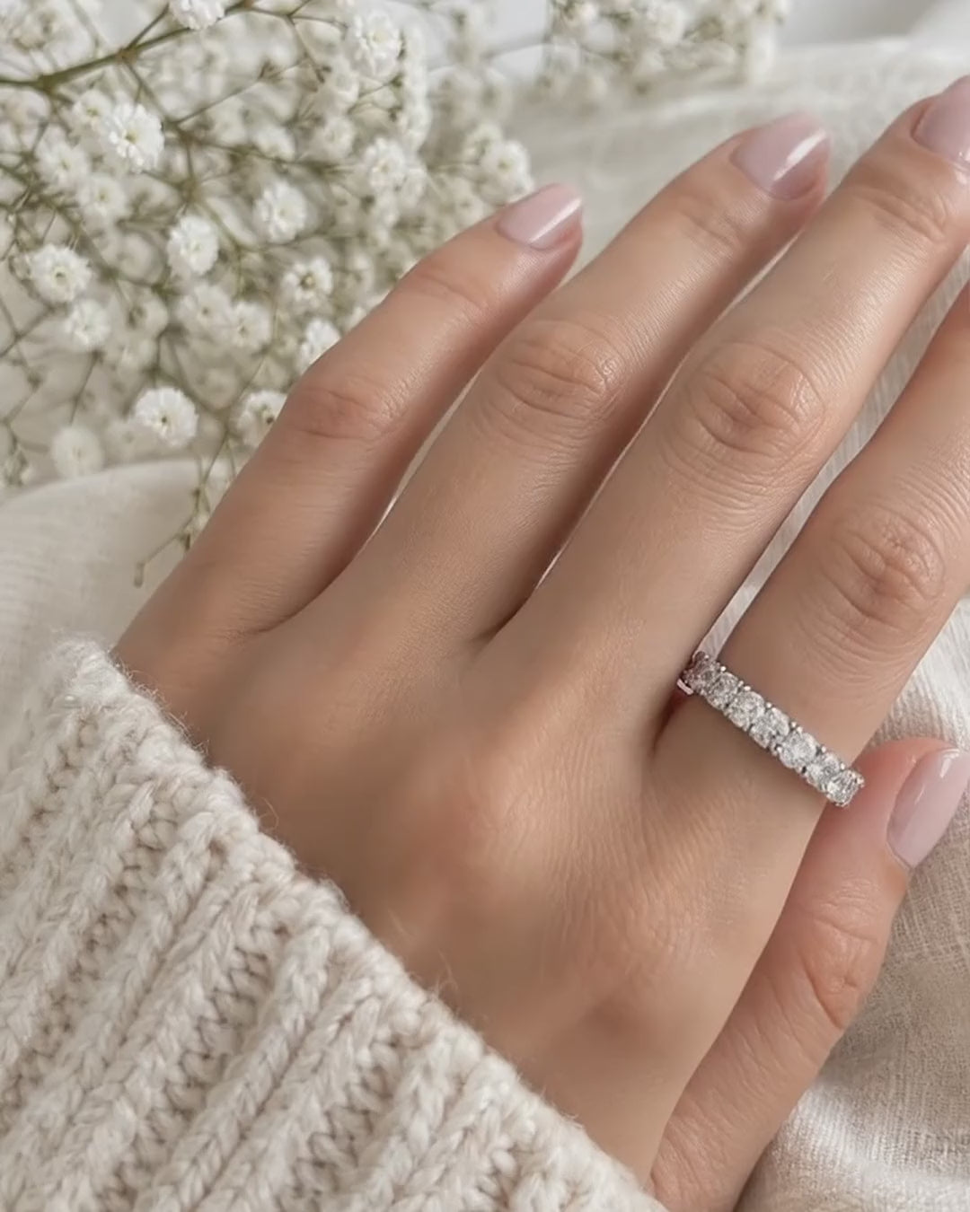 Half eternity ring in 14K white gold with round diamonds, worn on a hand