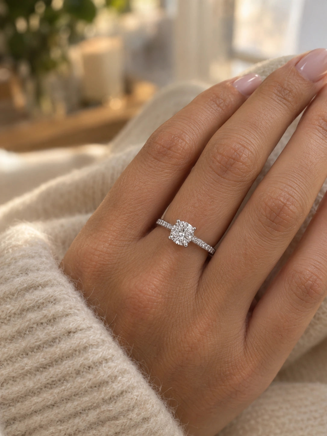 Round solitaire engagement ring in 14K white gold worn on a hand to show its size