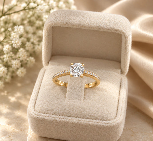 Round solitaire engagement ring in 14K yellow gold with a pavé diamond band, in a velvet ring box