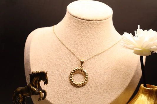 Sunburst circle pendant necklace in 14K gold on a linen jewellery bust