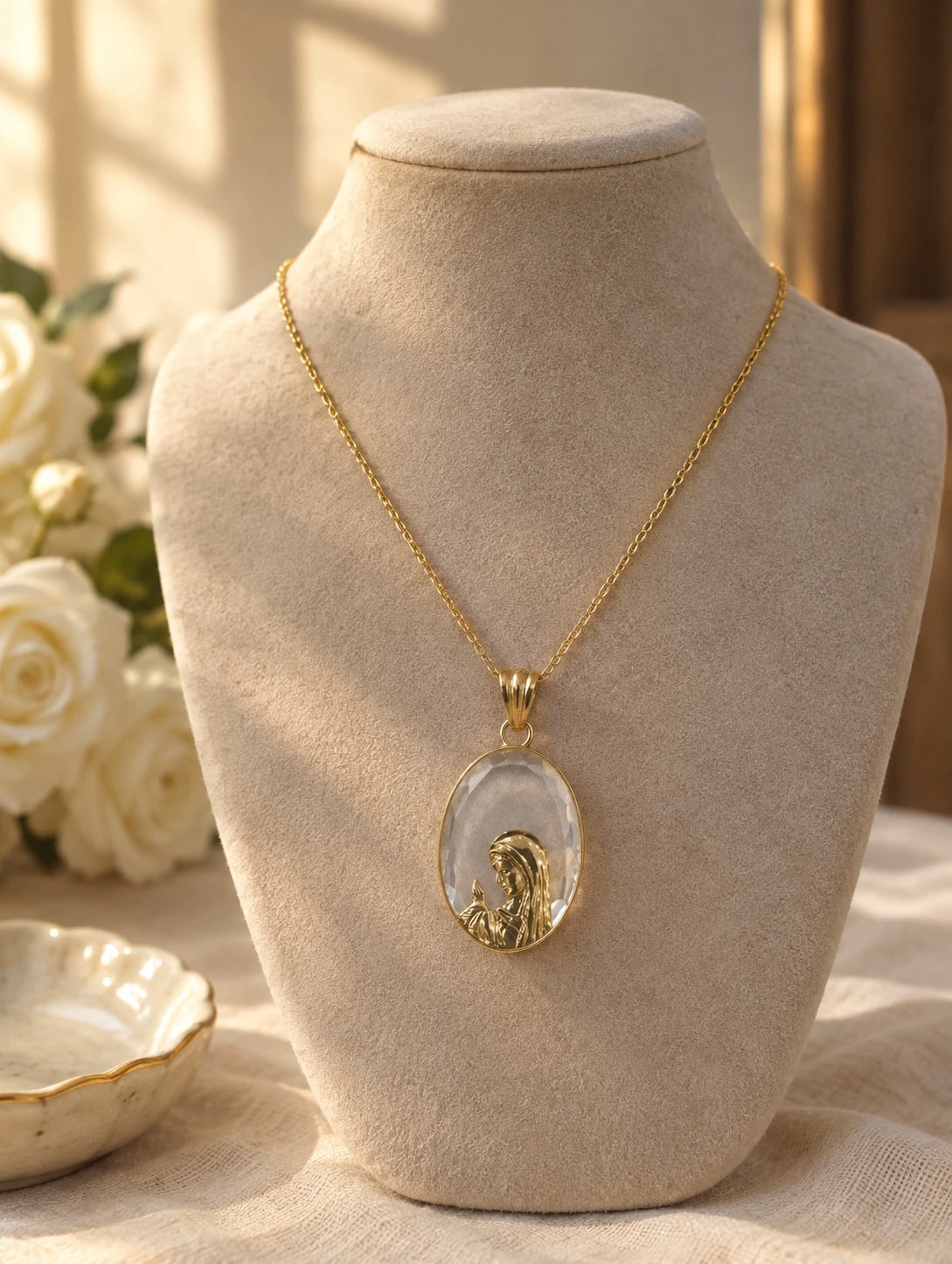 Clear stone Virgin Mary pendant necklace in 14K gold on a jewelry bust
