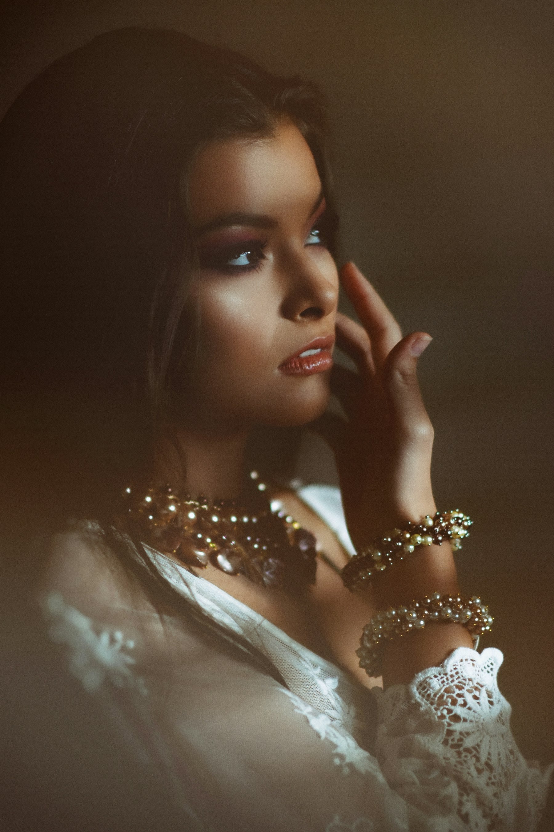Model wearing layered gold bracelets